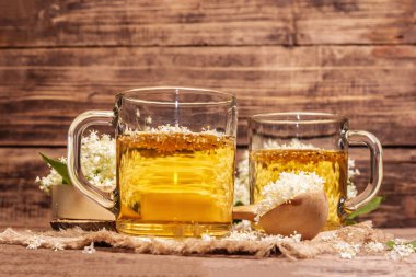 Mürver çiçeği çayı. Taze yaz içkisi, sağlıklı yaşam tarzı konsepti. Kumaş peçete, eski ahşap masa, kopyalama alanı