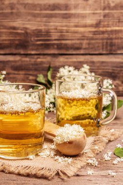 Mürver çiçeği çayı. Taze yaz içkisi, sağlıklı yaşam tarzı konsepti. Kumaş peçete, eski ahşap masa, kapatın.