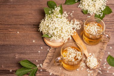 Mürver çiçeği çayı. Taze yaz içkisi, sağlıklı yaşam tarzı konsepti. Kumaş peçete, eski ahşap masa, üst manzara.