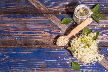 Taze mürver çiçekleri. Sağlıklı gıda konsepti için. Modern sert ışık, karanlık gölge. Mavi vintage tahta arka plan, üst görünüm