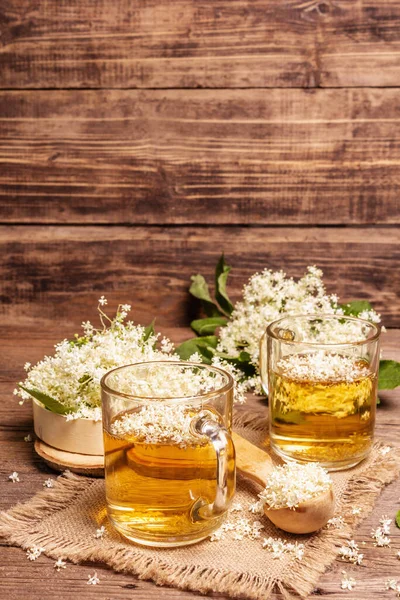 Mürver çiçeği çayı. Taze yaz içkisi, sağlıklı yaşam tarzı konsepti. Kumaş peçete, eski ahşap masa, kopyalama alanı