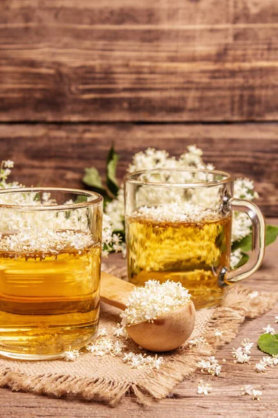 Mürver çiçeği çayı. Taze yaz içkisi, sağlıklı yaşam tarzı konsepti. Kumaş peçete, eski ahşap masa, kapatın.