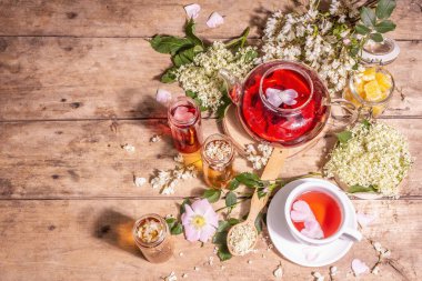 Çiçeklerden yapılmış çeşitli çay. Taze mürver, gül kalçası ve akasya. Sağlıklı gıda konsepti. Eski tahta arka plan, üst görünüm