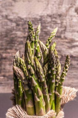 Çuval bezinde bir sürü kuşkonmaz. Sağlıklı yiyecekler için taze malzeme, siyah taş pişirme arka planı, kopyalama alanı