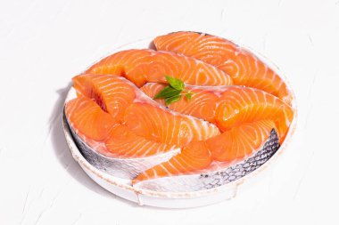 Taze çiğ somon ya da balık fileto bifteği. Minimalist tasarım, modern sert ışık, karanlık gölge. Sağlıklı deniz ürünleri pişirmek için soğutulmuş malzemeler. Beyaz macun mutfak arkaplanı, kopyalama alanı