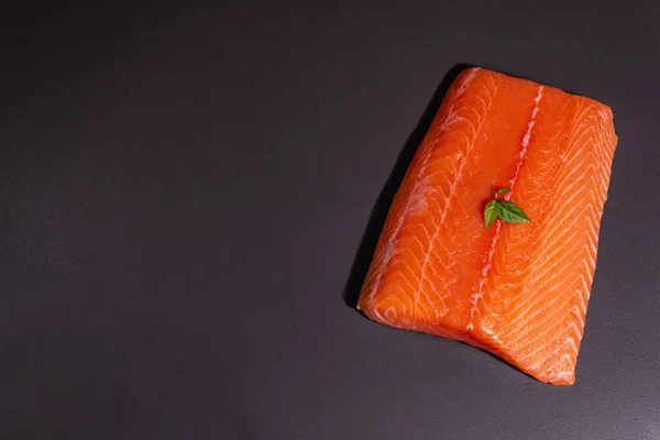 黒石の背景に新鮮な生鮭やマスの魚の切り身 健康食品 オメガ3のソースのための有用な成分 現代的なハードライト 暗い影 料理の壁紙 トップビュー — ストック写真