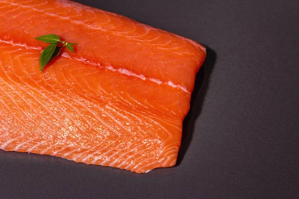 黒石の背景に新鮮な生鮭やマスの魚の切り身 健康食品 オメガ3のソースのための有用な成分 現代的なハードライト 暗い影 料理の壁紙 トップビュー — ストック写真