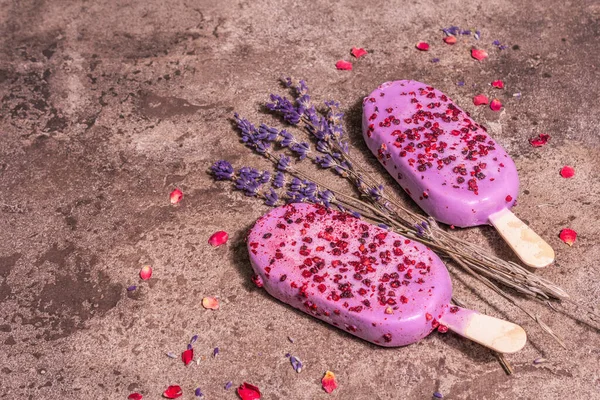 Lavender ice cream. Flower bouquet, pink rose petals. Trendy hard light, dark shadow. Marble stone background, copy space, flat lay