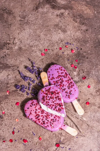 Lavender ice cream. Flower bouquet, pink rose petals. Trendy hard light, dark shadow. Marble stone background, top view, flat lay