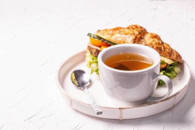 Sağlıklı kahvaltı konsepti. Günaydın, çay ve kruvasanla. Beyaz macun arkaplanı, kopyalama alanı