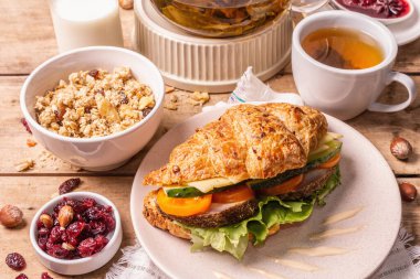 Sağlıklı kahvaltı konsepti. Günaydın, çay, kruvasan, tahıl gevreği, süt ve reçelle. Vintage ahşap masa, kapat.