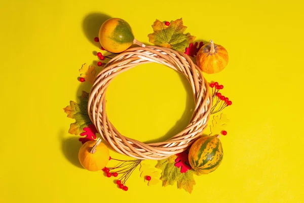 カボチャ 果実と秋の装飾の背景 鮮やかな黄色のパステルの背景に編組花輪 トップビュー — ストック写真