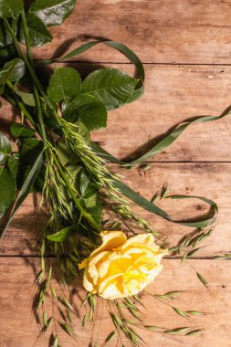 Gül dekoratif geçmişi. Taze sarı çiçek, sert ışık, koyu gölge. Eski tahta tahta arka plan, metin için yer