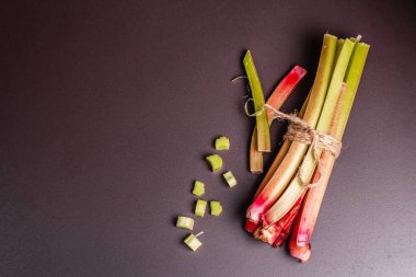 Taze ravent sapları ve siyah taş arka planda kesikler. Sağlıklı malzeme, yararlı gıda konsepti, üst görünüm.