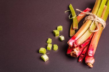 Taze ravent sapları ve siyah taş arka planda kesikler. Sağlıklı malzeme, yararlı gıda konsepti, kopyalama alanı