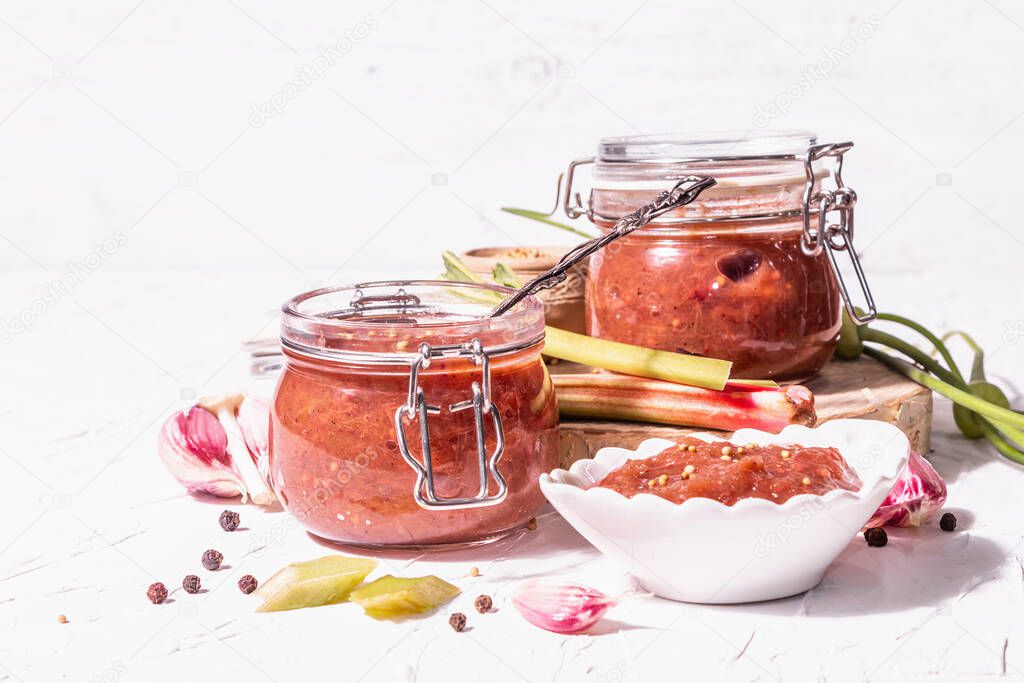 Chutney from rhubarb. Set of ingredients and spices for cooking. White putty background, close up