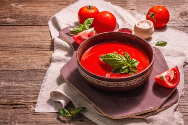 Fesleğenli domates çorbası. Olgun sebzeler, taze yeşiller, mis kokulu baharatlar. Eski tahta tablo, kopyala alanı