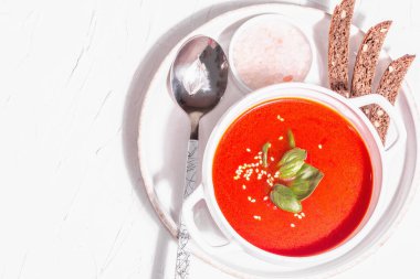 Domatesli, yeşillikli ve ekmekli püre çorbası. Modaya uygun sert ışık, karanlık gölge. Beyaz macun arkaplan, üst görünüm