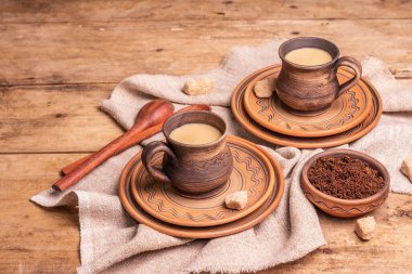 Sıcak bir ev tarzında afromatik kahve. Seramik kupalar, sıcak içecek, ahşap masa. Günaydın, iyi ruh hali, fotokopi alanı