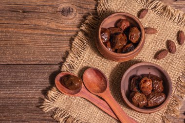 Seramik kasede güneşte kurutulmuş zeytin. Geleneksel Yunan aperatifleri, kuru tohumlar, eski ahşap masa. Mutfak, üst manzara.