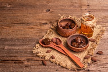 Seramik kâse ve zeytinyağında kurutulmuş zeytin. Geleneksel Yunan aperatifleri, kuru tohumlar, eski ahşap masa. Mutfak arkaplanı, kopyalama alanı