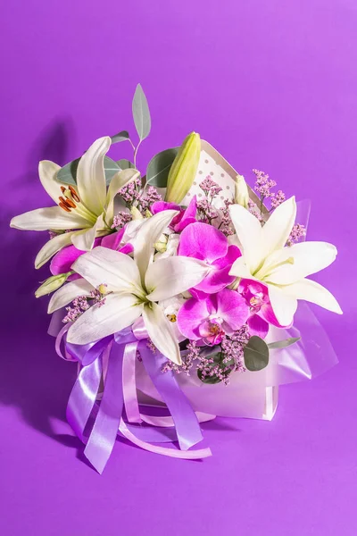 A beautiful bouquet of fresh flowers on a violet background. The festive concept for Weddings, Birthdays, Mother\'s Day, For Valentine, or March 8th. Greeting card, a place for text, flat lay