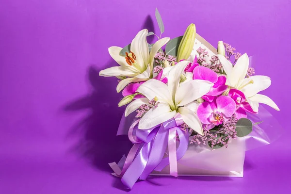 A beautiful bouquet of fresh flowers on a violet background. The festive concept for Weddings, Birthdays, Mother\'s Day, For Valentine, or March 8th. Greeting card, a place for text, flat lay
