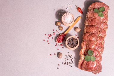 Çiğ domuz filetosu. Baharatlı mutfak ipiyle marine edilmiş taze et. Modaya uygun sert bir ışık, karanlık bir gölge, taş beton zemin, üst görünüm