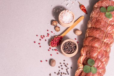 Çiğ domuz filetosu. Baharatlı mutfak ipiyle marine edilmiş taze et. Modaya uygun sert bir ışık, karanlık bir gölge, taş beton zemin, üst görünüm