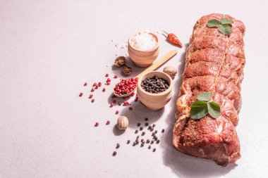 Çiğ domuz filetosu. Baharatlı mutfak ipiyle marine edilmiş taze et. Modaya uygun bir sert ışık, karanlık gölge, taş beton zemin, kopyalama alanı
