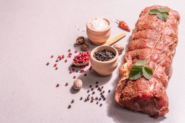 Çiğ domuz filetosu. Baharatlı mutfak ipiyle marine edilmiş taze et. Modaya uygun bir sert ışık, karanlık gölge, taş beton zemin, kopyalama alanı