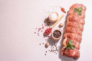 Çiğ domuz filetosu. Baharatlı mutfak ipiyle marine edilmiş taze et. Modaya uygun sert bir ışık, karanlık bir gölge, taş beton zemin, üst görünüm