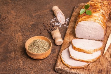 Taş zeminde ev yapımı domuz filetosu. Tam kavrulmuş parça, baharatlı dilimler, düz yatak, yakın çekim.