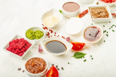 Farklı soslar - ketçap, mayonez, barbekü, soya, turşu, wasabi, adjika, yaban turpu, aioli, marinara. Modaya uygun sert ışık, karanlık gölge. Beyaz macun arkaplanı, kopyalama alanı