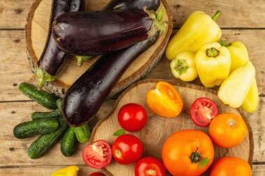 Ahşap arka planda taze sebze çeşitleri. Olgun domates, patlıcan, salatalık ve dolmalık biber.