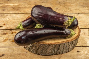 Tahta tezgahta olgun patlıcanlar. Taze organik sebzeler, mutfak masası. Yeni hasat, kopyalama alanı