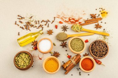 Köri pişirmek için bir çift baharat. Aromatik baharatlar: zerdeçal, paprika, kakule, tarçın, yıldız anason, kırmızı biber, kuru otlar, tuz. Hafif taş arkaplan, üst görünüm