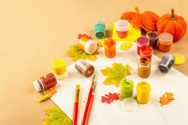 Yaratıcı sonbahar renk kompozisyonu. Gouache, fırça, kağıt, geleneksel dekor. Sanat, ruh hali, hobi ya da yaşam tarzı. Açık bej arkaplan, düz yatış, kopyalama alanı