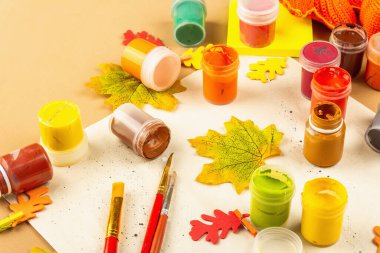 Yaratıcı sonbahar renk kompozisyonu. Gouache, fırça, kağıt, geleneksel dekor. Sanat, ruh hali, hobi ya da yaşam tarzı. Açık bej arkaplan, düz yatış, kopyalama alanı