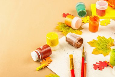 Yaratıcı sonbahar renk kompozisyonu. Gouache, fırça, kağıt, geleneksel dekor. Sanat, ruh hali, hobi ya da yaşam tarzı. Açık bej arkaplan, düz yatış, kopyalama alanı