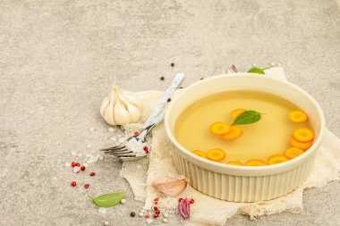 Sebze ve baharatlı şeffaf tavuk çorbası. Geleneksel bulyon, sağlıklı yemek. Hafif taş arkaplan, boşluğu kopyala