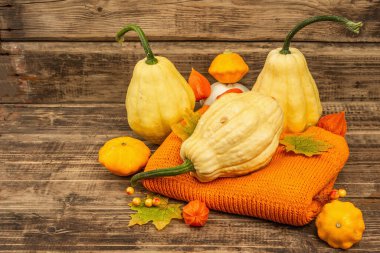 Sonbahar tarzı kompozisyon. Olgun balkabakları, sıcak örülmüş süveter, sonbahar yaprakları ve böğürtlen. Şükran Günü ya da Cadılar Bayramı keyfi. Eski tahta arkaplan