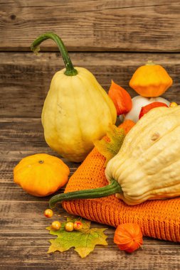 Sonbahar tarzı kompozisyon. Olgun balkabakları, sıcak örülmüş süveter, sonbahar yaprakları ve böğürtlen. Şükran Günü ya da Cadılar Bayramı keyfi. Eski tahta arkaplan