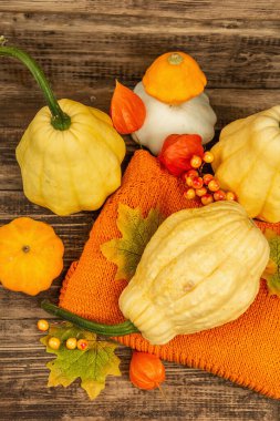 Sonbahar tarzı kompozisyon. Olgun balkabakları, sıcak örülmüş süveter, sonbahar yaprakları ve böğürtlen. Şükran Günü ya da Cadılar Bayramı keyfi. Eski ahşap zemin, üst manzara