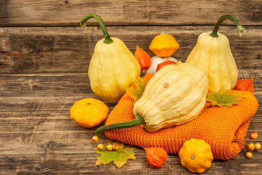 Sonbahar tarzı kompozisyon. Olgun balkabakları, sıcak örülmüş süveter, sonbahar yaprakları ve böğürtlen. Şükran Günü ya da Cadılar Bayramı keyfi. Eski tahta arkaplan