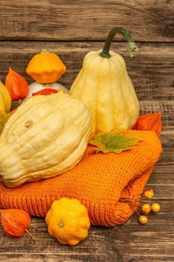 Sonbahar tarzı kompozisyon. Olgun balkabakları, sıcak örülmüş süveter, sonbahar yaprakları ve böğürtlen. Şükran Günü ya da Cadılar Bayramı keyfi. Eski tahta arkaplan