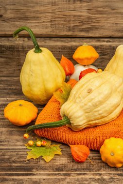 Sonbahar tarzı kompozisyon. Olgun balkabakları, sıcak örülmüş süveter, sonbahar yaprakları ve böğürtlen. Şükran Günü ya da Cadılar Bayramı keyfi. Eski tahta arkaplan