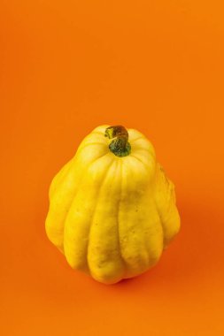 Parlak turuncu arka planda izole edilmiş olgun sarı balkabağı. Cadılar Bayramı ya da Şükran Günü için geleneksel dekoratif öğe.