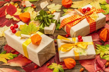 Sonbahar tasarımlı sıfır atık hediye konsepti. Sıcak kazaklar, dökülen yapraklar, tematik dekorasyon. Yumuşak ışık, eski tahta arka plan, düz uzanma
