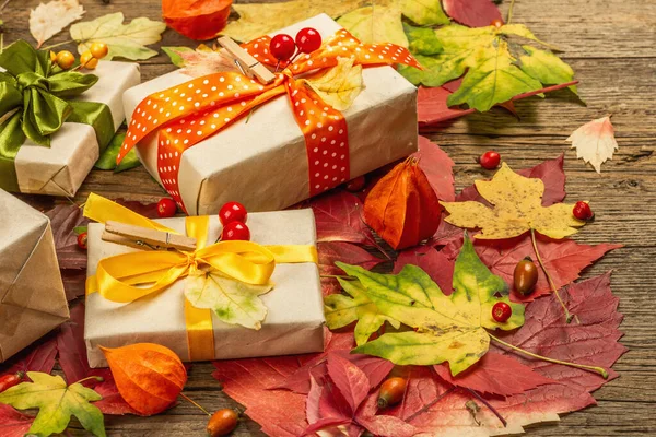 Sonbahar tasarımlı sıfır atık hediye konsepti. Sıcak kazaklar, dökülen yapraklar, tematik dekorasyon. Yumuşak ışık, eski tahta arka plan, düz uzanma